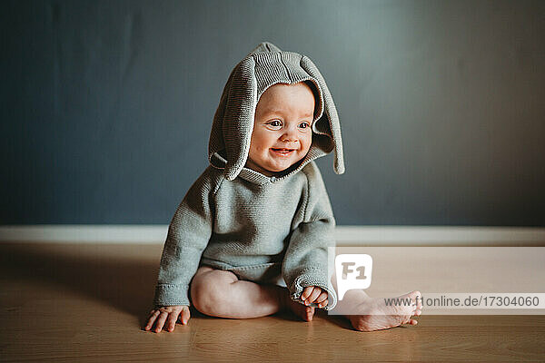 Entzückendes lächelndes Baby  das ein Hasenkostüm trägt  um Ostern zu feiern