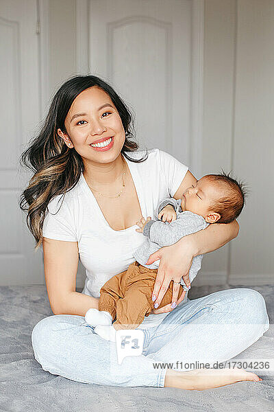 Urlaub zum Muttertag. Stolze lächelnde asiatische Mutter mit neugeborenem Baby Junge