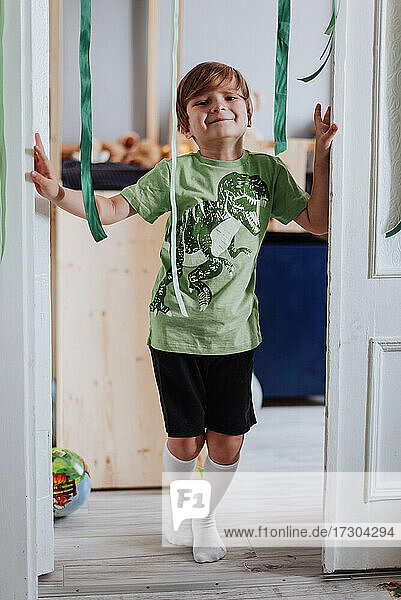 5 years boy playing in his room  wearing green t-shirt with dinosaurus print