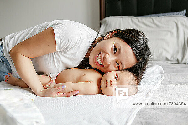Mothers day holiday. Happy Chinese Asian mother hugging newborn son.