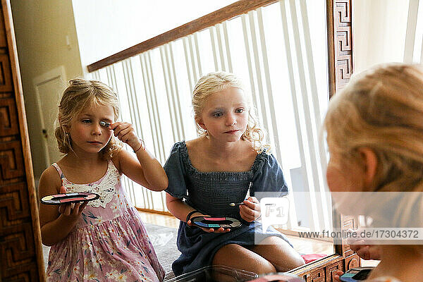 kleine Mädchen  die sich gemeinsam vor dem Spiegel schminken