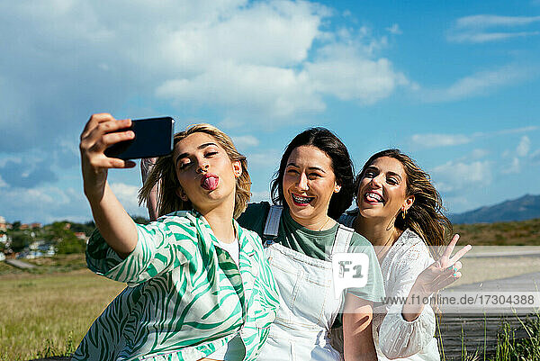 Lächelnde Mädchen  die gemeinsam ein Selfie im Freien machen