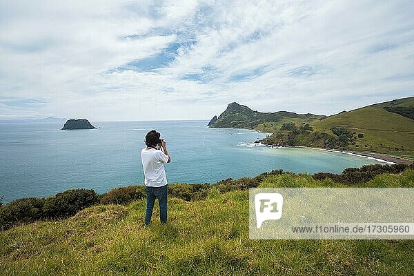 Guy with camera at Fletcher Bay  Coromandel  North Island  New Zealand  Oceania