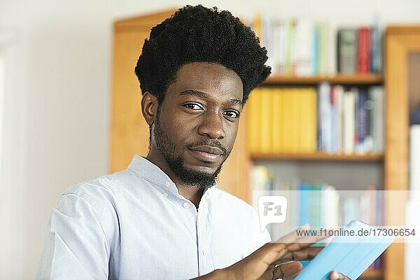 Student mit Afrolook lernend in Bibliothek  Freiburg  Baden-Württemberg  Deutschland  Europa