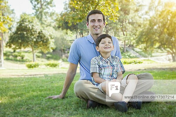 Handsome gemischtrassigen Vater und jungen Sohn Porträt im Park