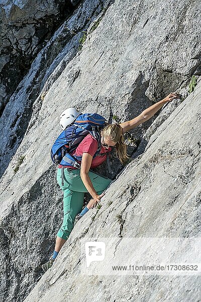 Young woman climbing along a rock face  hiking to the Hochkalter  Berchtesgadener Alpen  Berchtesgadener Land  Upper Bavaria  Bavaria  Germany  Europe