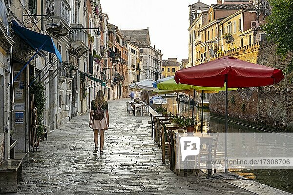 Junge Frau geht an einem Kanal entlang  Venedig  Venetien  Italien  Europa