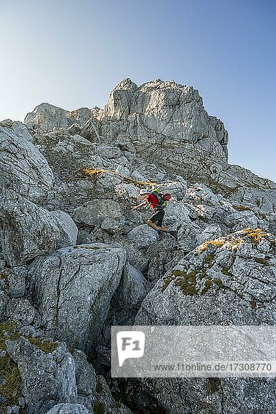 Mann springt von Felsen zu Felsen  Wanderung zum Hochkalter  Berchtesgadener Alpen  Berchtesgadener Land  Oberbayern  Bayern  Deutschland  Europa