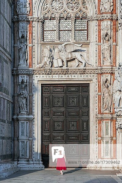 Junge Frau vor Eingangstor des Dogenpalasts  am Markusplatz  Venedig  Venetien  Italien  Europa