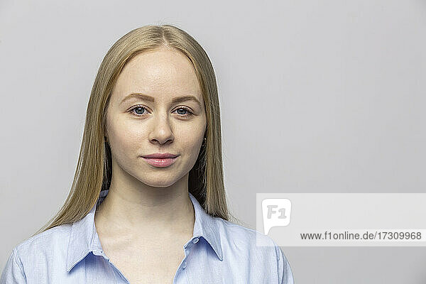 Porträt selbstbewusste junge Frau auf grauem Hintergrund