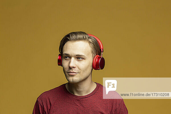 Studio Porträt junger Mann mit Kopfhörer hören Musik