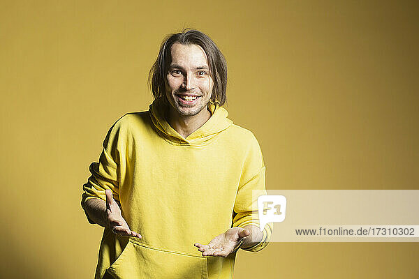 Porträt glücklich  aufgeregt junger Mann auf gelbem Hintergrund