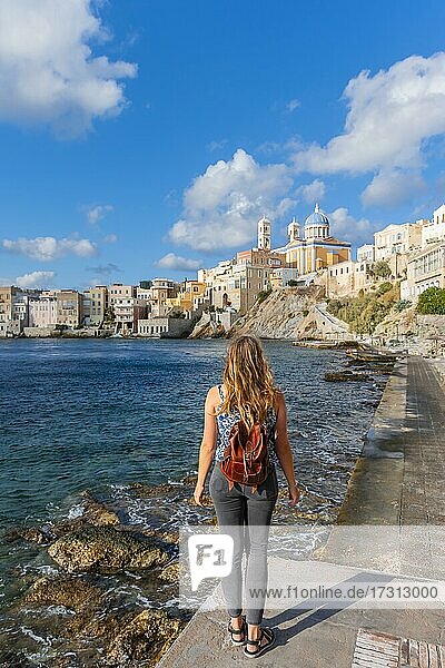 Junge Touristin am Meer  Blickt auf Stadt  Kirche des Heiligen Nikolaus  Agios Nikolaos  Ermoupoli  Syros  Kykladen  Griechenland  Europa