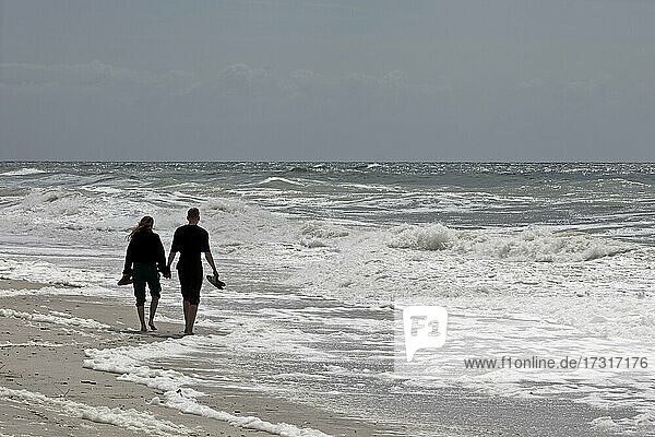 Young couple walking on the beach at the surf  North Sea  West Coast Hörnum  Sylt  North Frisia  Schleswig-Holstein  Germany  Europe