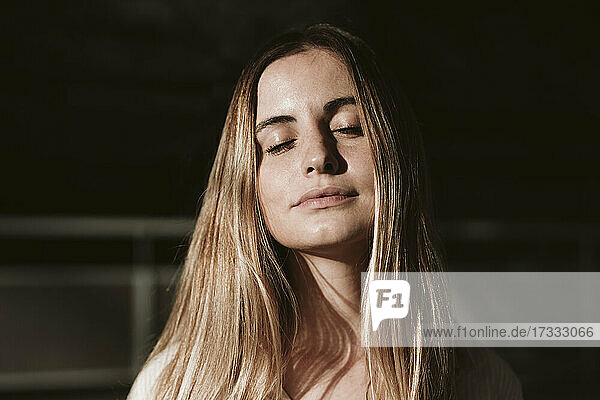 Beautiful young blond woman with eyes closed