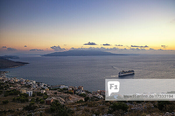 Sonnenuntergang über dem Ionischen Meer mit einem Kreuzfahrtschiff im Hintergrund