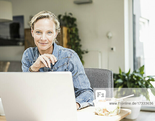 Businesswoman with eyeglasses staring while sitting at home office