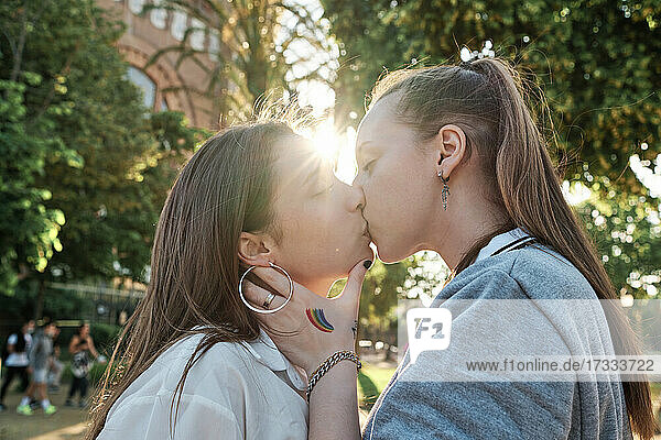 Young couple kissing on mouth at park