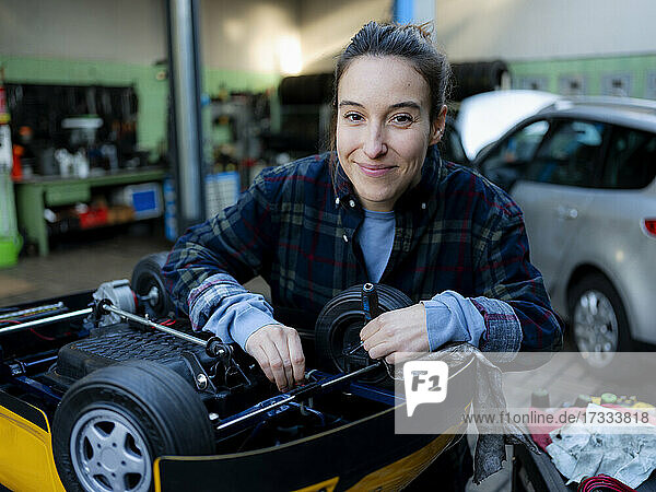 Mechanikerin bei der Arbeit an einem Spielzeugauto in der Werkstatt