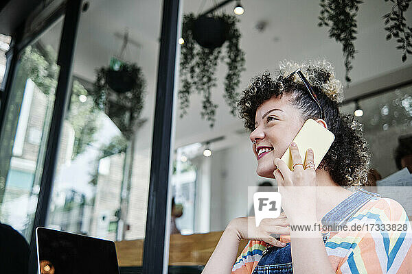 Schöne Frau spricht in einem Straßencafé mit ihrem Handy
