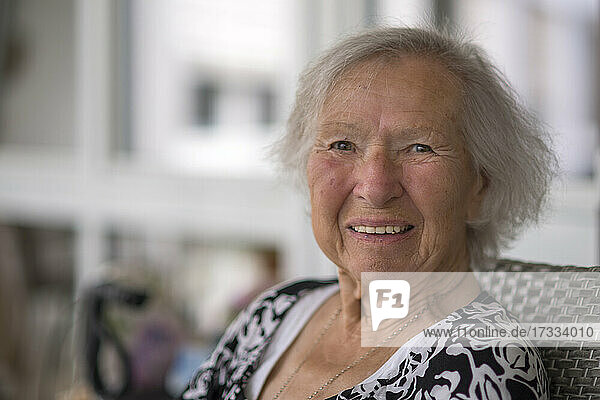 Lächelnde ältere Frau auf einem Stuhl sitzend