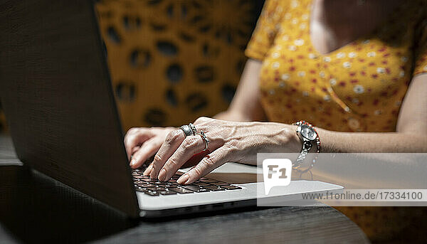 Frau mit Laptop am Tisch in einem Kaffeehaus