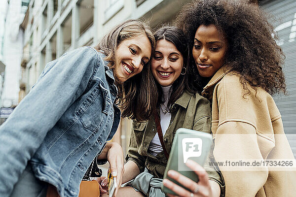 Young women smiling while taking selfie through mobile phone