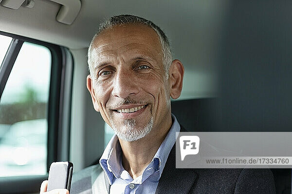 Lächelnde männliche Fachkraft im Auto sitzend