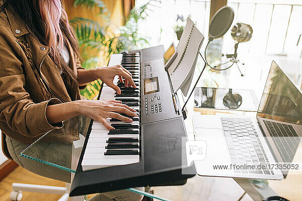 Musikerin spielt zu Hause E-Piano