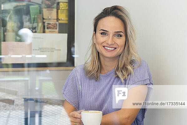 Lächelnde junge Frau bei einem Kaffee im Café