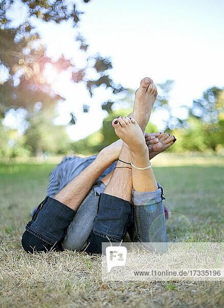 Couple resting together on grass at park
