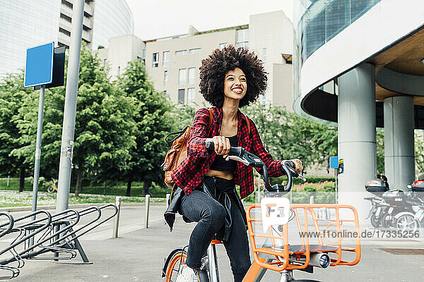 Fröhliche junge Frau beim Radfahren in der Stadt