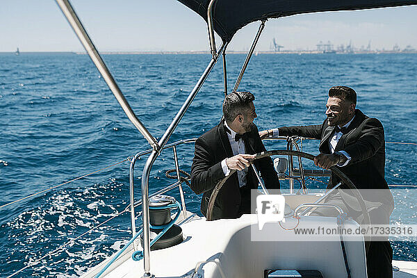 Male friends talking while yachting during summer