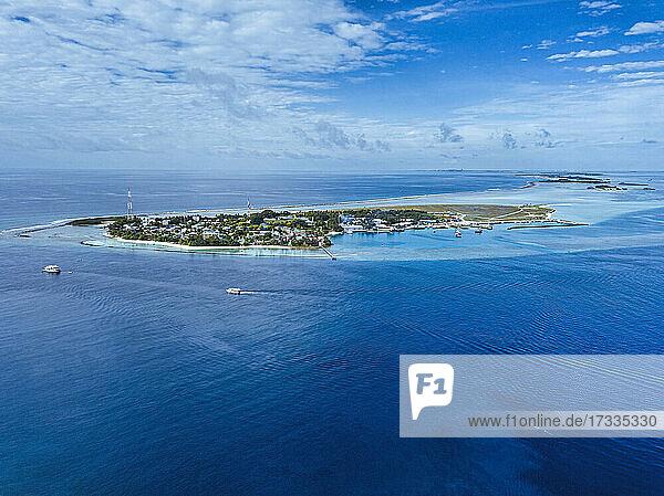 Thulusdhoo island on blue sea under sky at   Kaafu atoll  Maldives