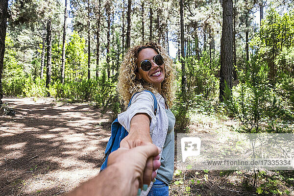 Mature couple holding hands while exploring in forest