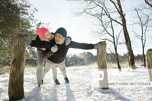 Lächelnde Frau umarmt Mann beim Sport im Schnee
