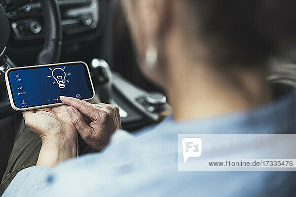 Frau benutzt Mobiltelefon  während sie im Auto sitzt