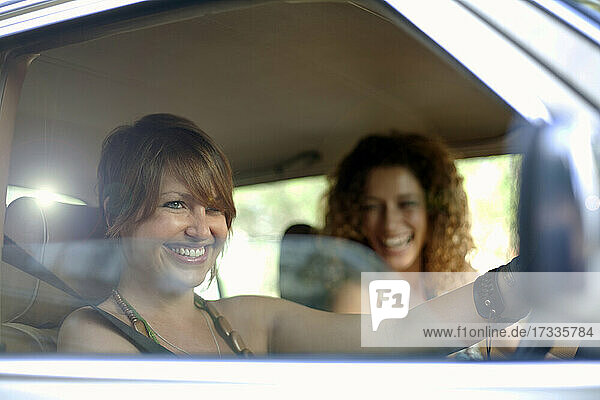 Happy female friends in car during road trip