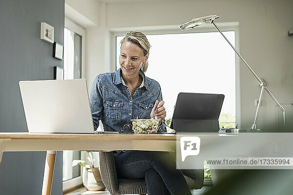 Freiberuflerin mit Laptop im Home-Office sitzend