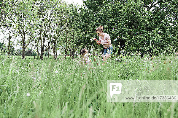 Mutter und Tochter spielen auf dem Rasen im Park