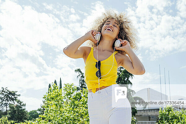 Happy young woman dancing while wearing headphones