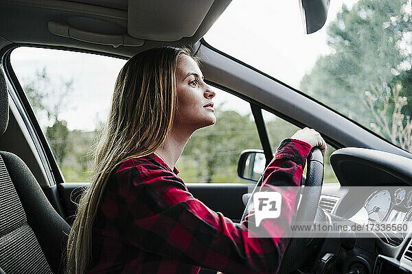 Beautiful young woman driving in car