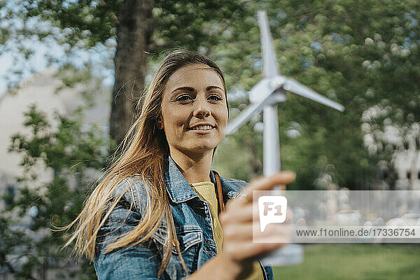 Young woman looking at wind turbine model