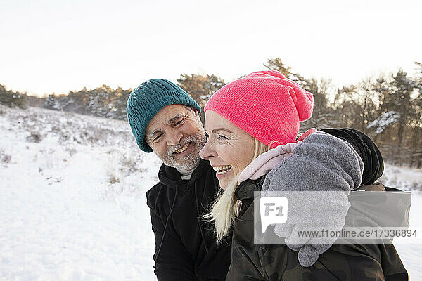 Smiling man with arm around woman during winter