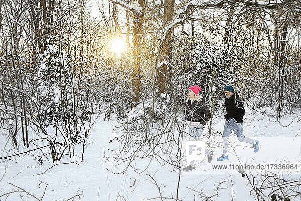 Älterer Mann und Frau laufen im Wald im Winter