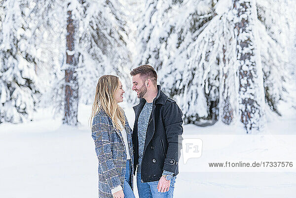 Smiling couple looking at each other during winter