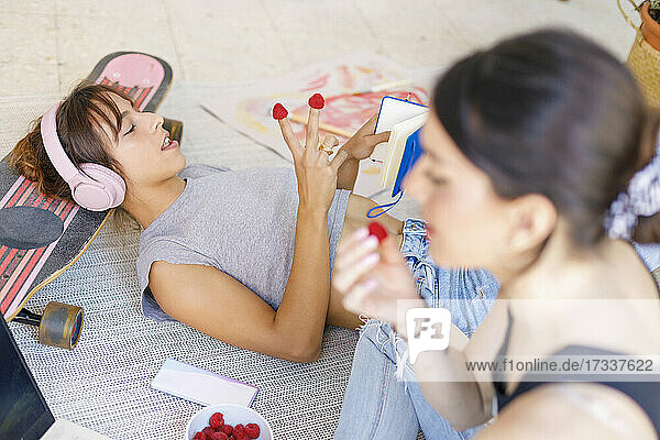 Female creative professionals eating raspberries in studio