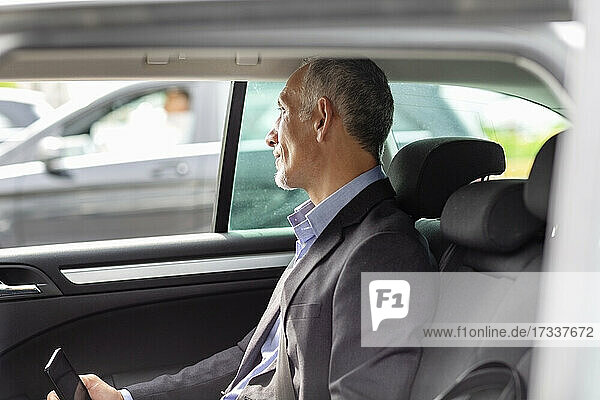 Männlicher Berufstätiger schaut durch das Fenster  während er im Auto sitzt