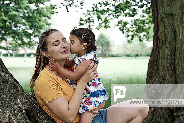 Nettes Mädchen küsst Mutter im Park