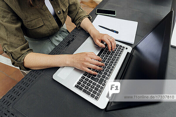 Freiberuflerin mit Laptop am Schreibtisch sitzend